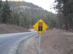 The hard-surfaced pavement changes to an earth road or low-type surface. Slow down