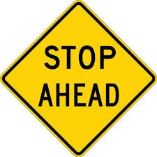 There is a stop sign ahead. Begin to slow down and be prepared to stop