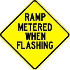This sign will have yellow lights flashing (top and bottom) when the freeway ramp ahead is metered. The ramp meter (red or green) directs motorists when to enter the freeway.